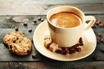 Cup of coffee and tasty cookies on wooden background