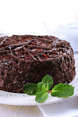 Tasty chocolate cake with mint on table close up