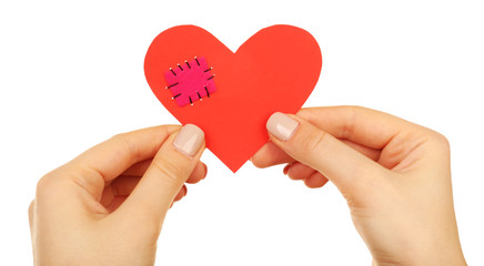 Obraz premium Female hands holding broken heart with patch isolated on white