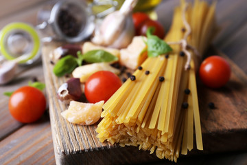 Raw pasta with cheese and vegetables on table close up