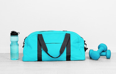 Sports bag with sports equipment in room