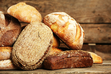 Different fresh bread on old wooden table