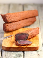 cured meat - basturma in hot pepper (paprika) on a cutting board