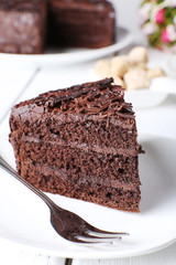 Piece of delicious chocolate cake in plate with fork
