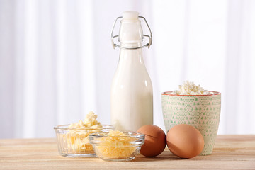 Different products on wooden table on blurred window background