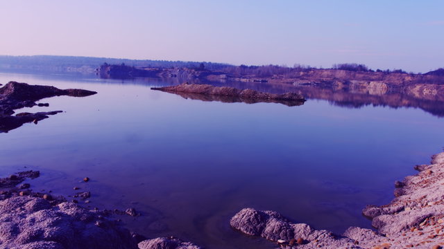 Pronounced blue lake with sandy orange purple dead sandy beach