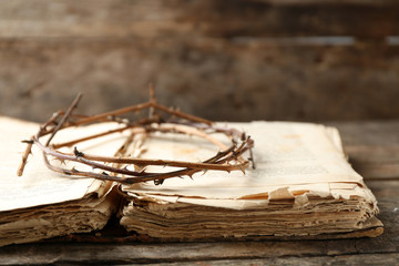 Crown of thorns and bible on old wooden background
