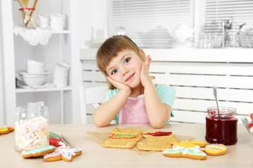 Little girl preparing cookies in kitchen at home