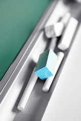 Chalk resting on school board, close up