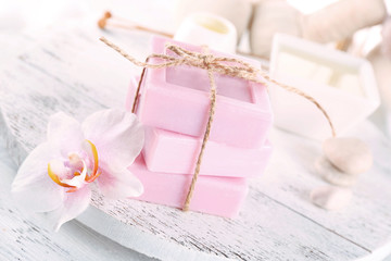 Stack of tied spa soap on wooden table, closeup