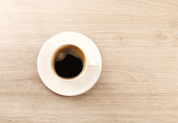 Cup of coffee on wooden table, top view