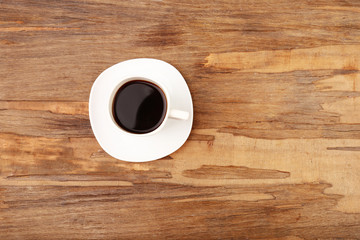 Cup of coffee on wooden table, top view