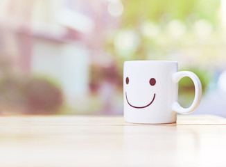 Happy cup on wood table. Concept about happiness and waiting for