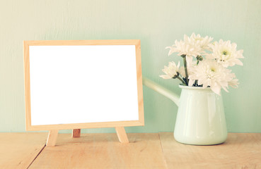 summer bouquet of flowers on the wooden table and blackboard wit