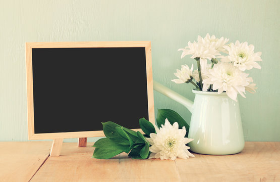 summer bouquet of flowers on the wooden table and blackboard wit