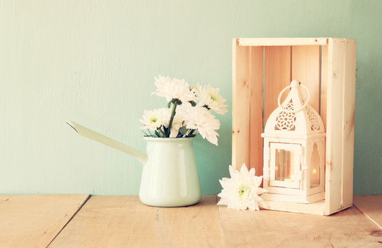 summer bouquet of flowers and vintage lantern on the wooden tabl