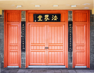 Red doors leading into a Buddhist temple located under the bronz