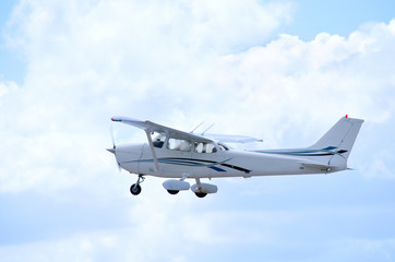 Small private single engine airplane in flight with clouds