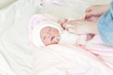 Fototapeta na wymiar Dressing a newborn baby