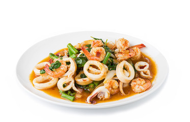 stir fried spicy seafood with herbs on white background