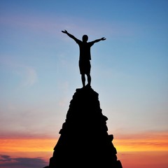 man on top of mountain in sunset