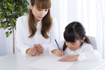 母親に勉強を教えてもらう子供