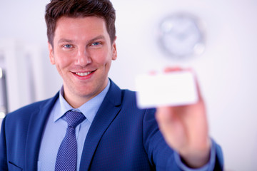Portrait of young man holding blank white card