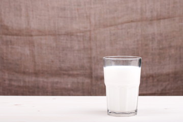 milk in a glass on the table side view