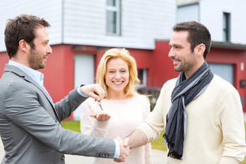 Real estate agent delivers keys to young atractive couple