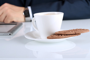Close up image of cup of coffee with cookies. business man worki