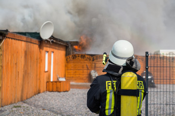 Feuerwehrmann vor einem brennenden Gebäude