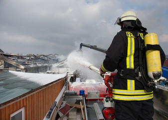 Feuerwehrmann beim löschen eines brennennden Gebäudes