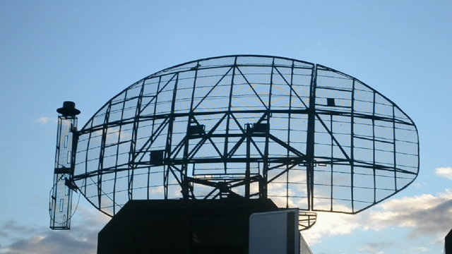 military radar station bearing on blue sky with clouds, modern direction finding satellite antenna rotated in automatic mode, ellipse technology diversity