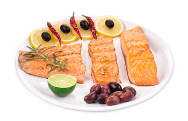 Grilled salmon steak with vegetables on plate.