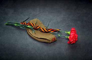 Carnation flowers, George Ribbon and military garrison cap