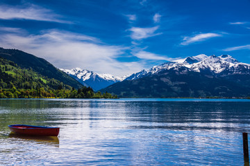 Zeller See mit rotem Ruderboot und Hohe Tauern