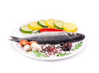 Fresh seabass with lemon and tomato on plate.