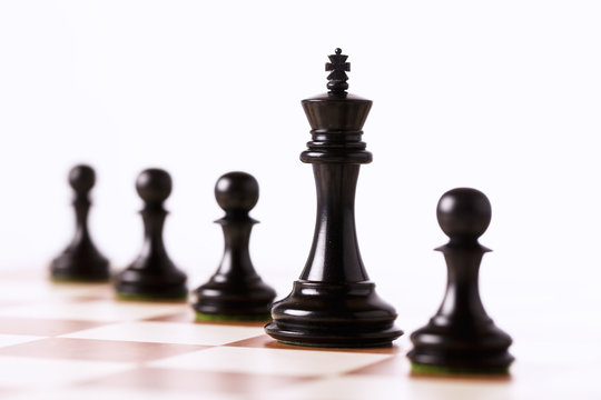 Black chess pieces on a chessboard isolated