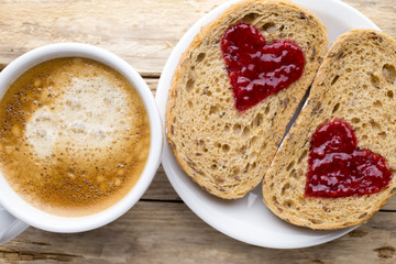Fresh coffee. Grain slice of bread with jam heart shape.