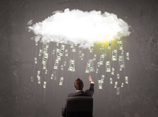 Business man in suit looking at cloud with falling money