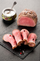 Roast beef with salt and pepper on stone board - obrazy, fototapety, plakaty