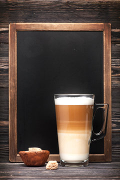 Cappuccino with sugar and menu chalkboard