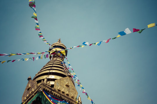 Buddha eyes close up with prayer flags at Bodhnath stupa in Kath