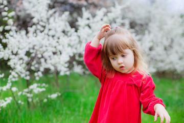 Adorable little girl in a flowered garden