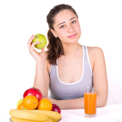 girl sitting near fruit and holding an apple