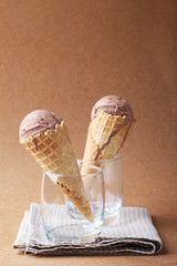 couple of chocolate flavor ice cream cones in a glass on matte b