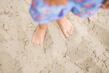 Toddler feet on sand at the beach