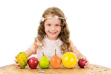Fototapeta premium Cute little preschooler girl with fruits on the table