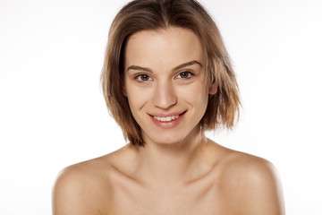 Happy young beautiful girl without make up on white background