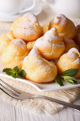 Profiteroles with powdered sugar close-up, vertical